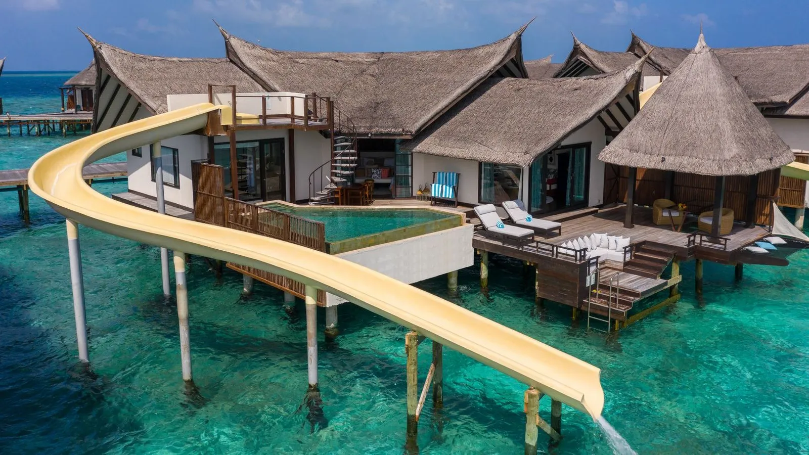 An Ocean Pool Suite with Slide: the yellow slide runs down from the deck into the lagoon.