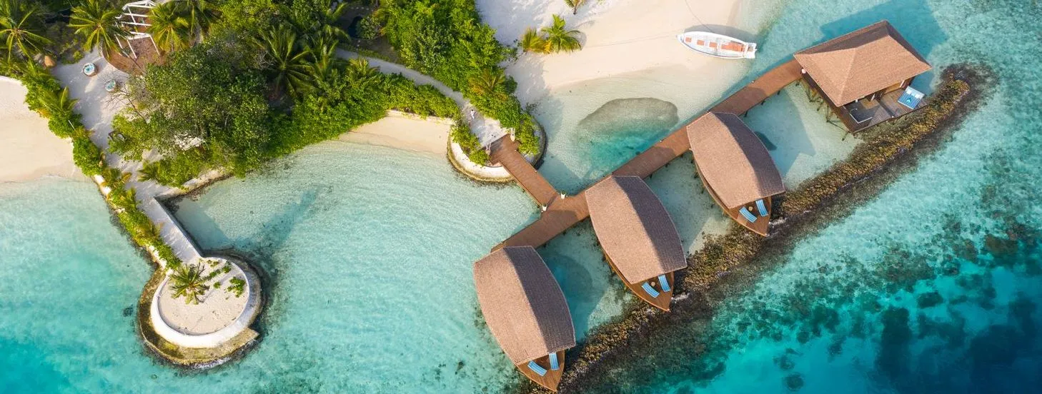 The ELE|NA spa from above: its treatment pavilions in a row over the lagoon, joined to the shore by a walkway.