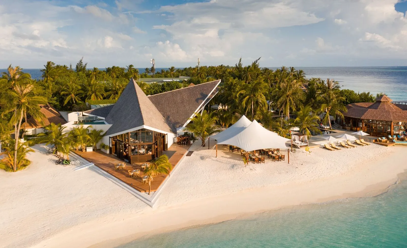 Vista del Mar from above: the restaurant’s pointed roof on the beach, its white awnings and the lagoon.