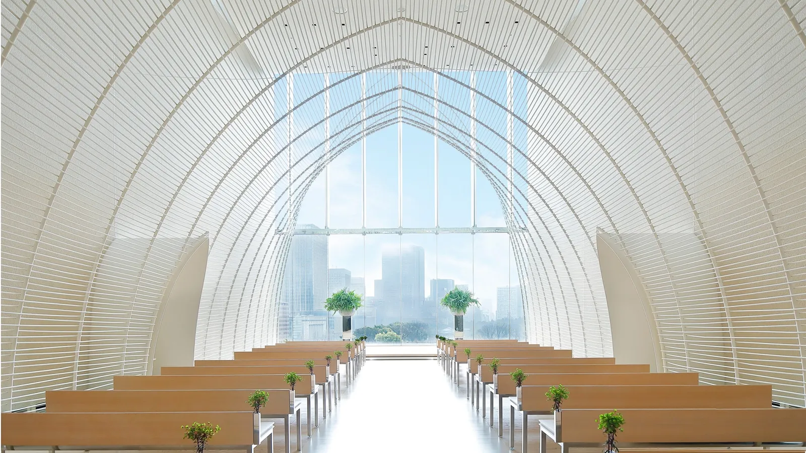 The wedding chapel, with its white timber arches, pews and the window onto the green and the towers.