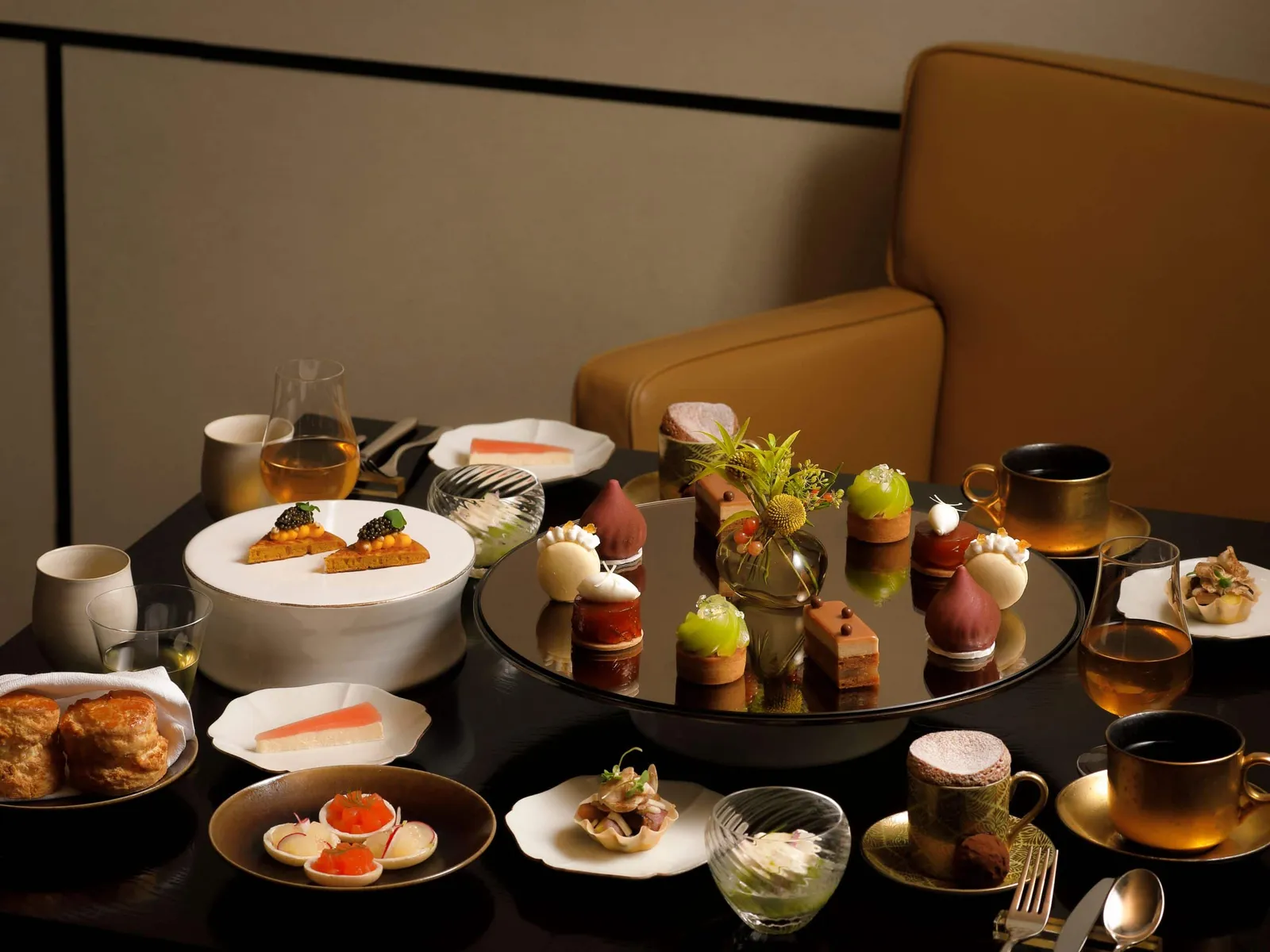 Afternoon tea in The Living Room: small sweet and savoury plates on the mirror stand, cups of Japanese tea.