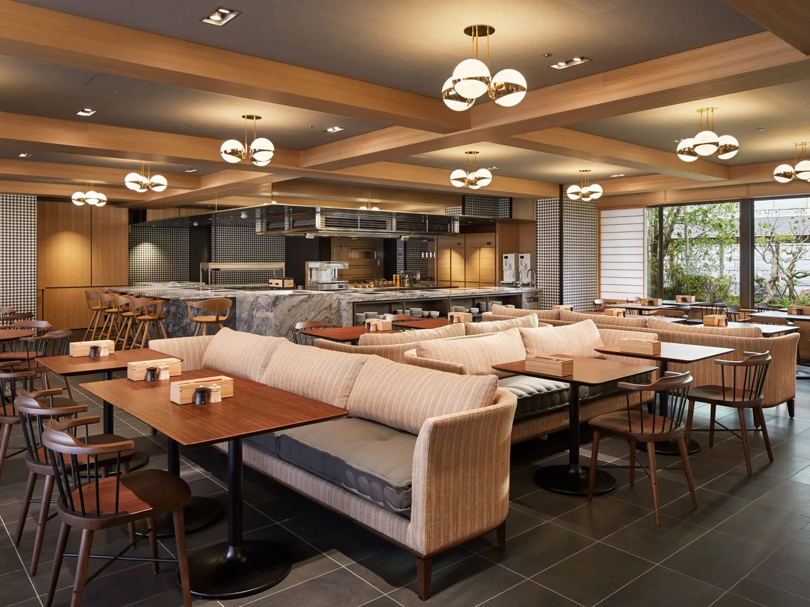 The Kyoto Bistro dining room: banquettes, globe lamps and the open kitchen at the back.