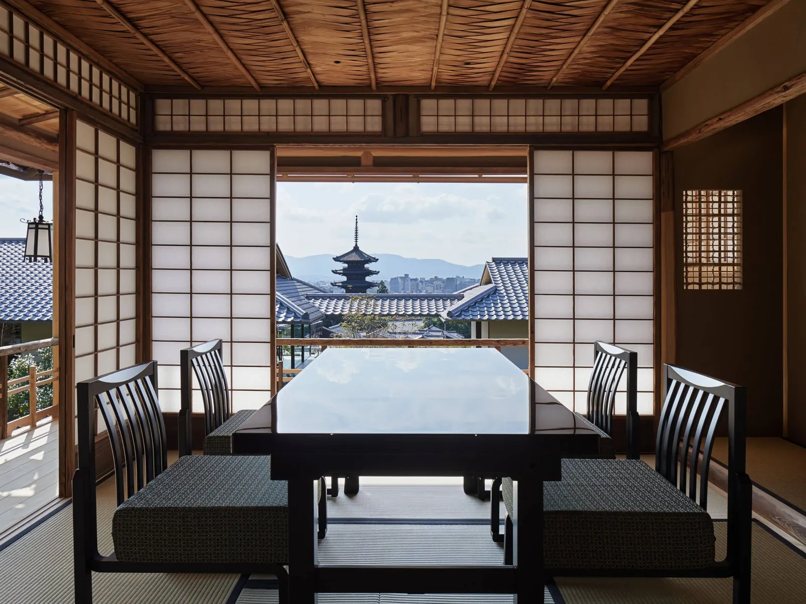 A room in the Kyoyamato teahouse: the dark table, the chairs and, through the open window, the pagoda above the roofs.