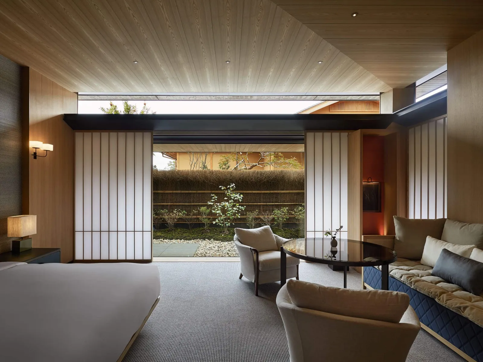 The 68 m² deluxe king room: a sitting area, paper screens and the glass onto a small garden.