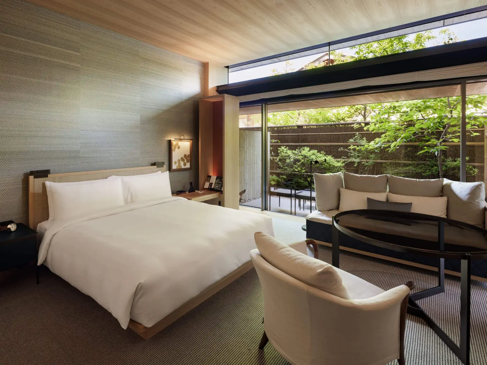 The garden-terrace king room: beyond the glass, the small private garden screened by bamboo.