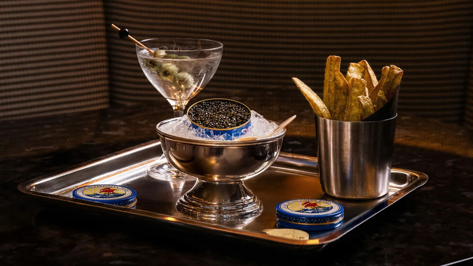 Caviar on ice, a cocktail and fries on a tray