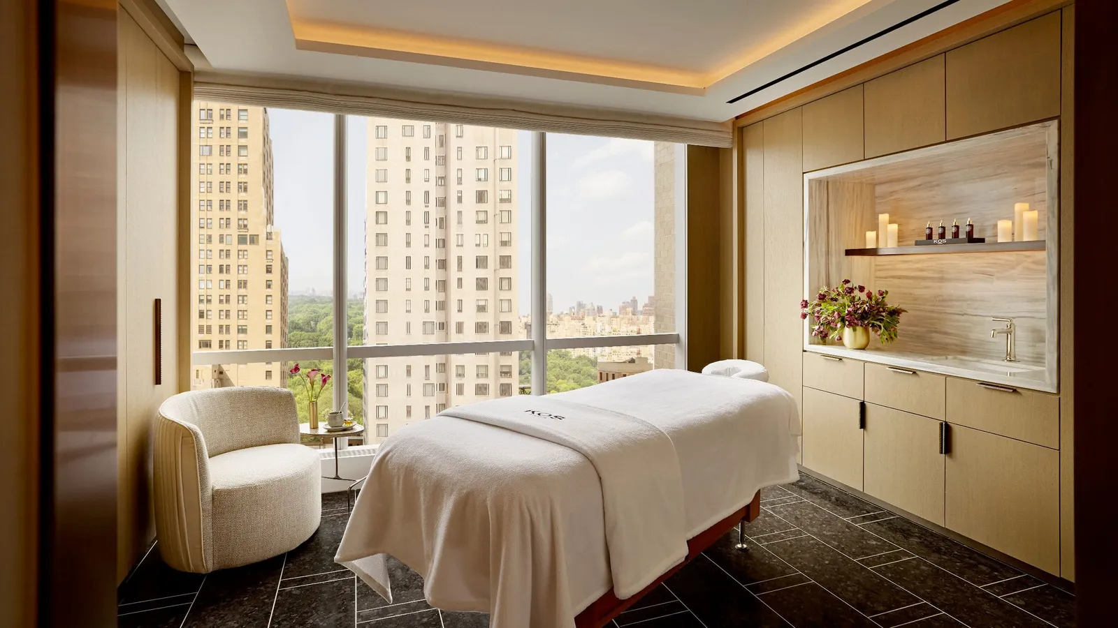 Treatment couch, armchair and basin beside the windows at Spa Nalai
