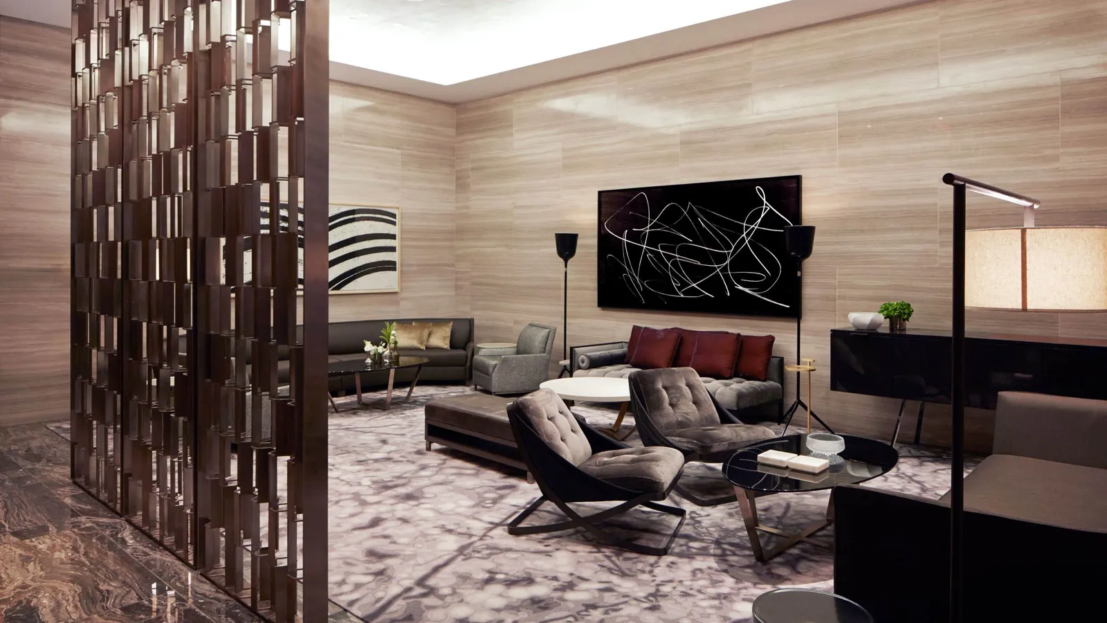 Lounge with grey armchairs, stone walls and abstract art