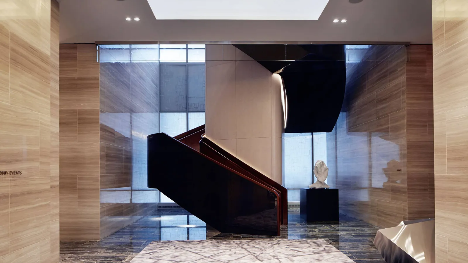 Dark curved staircase between pale stone walls