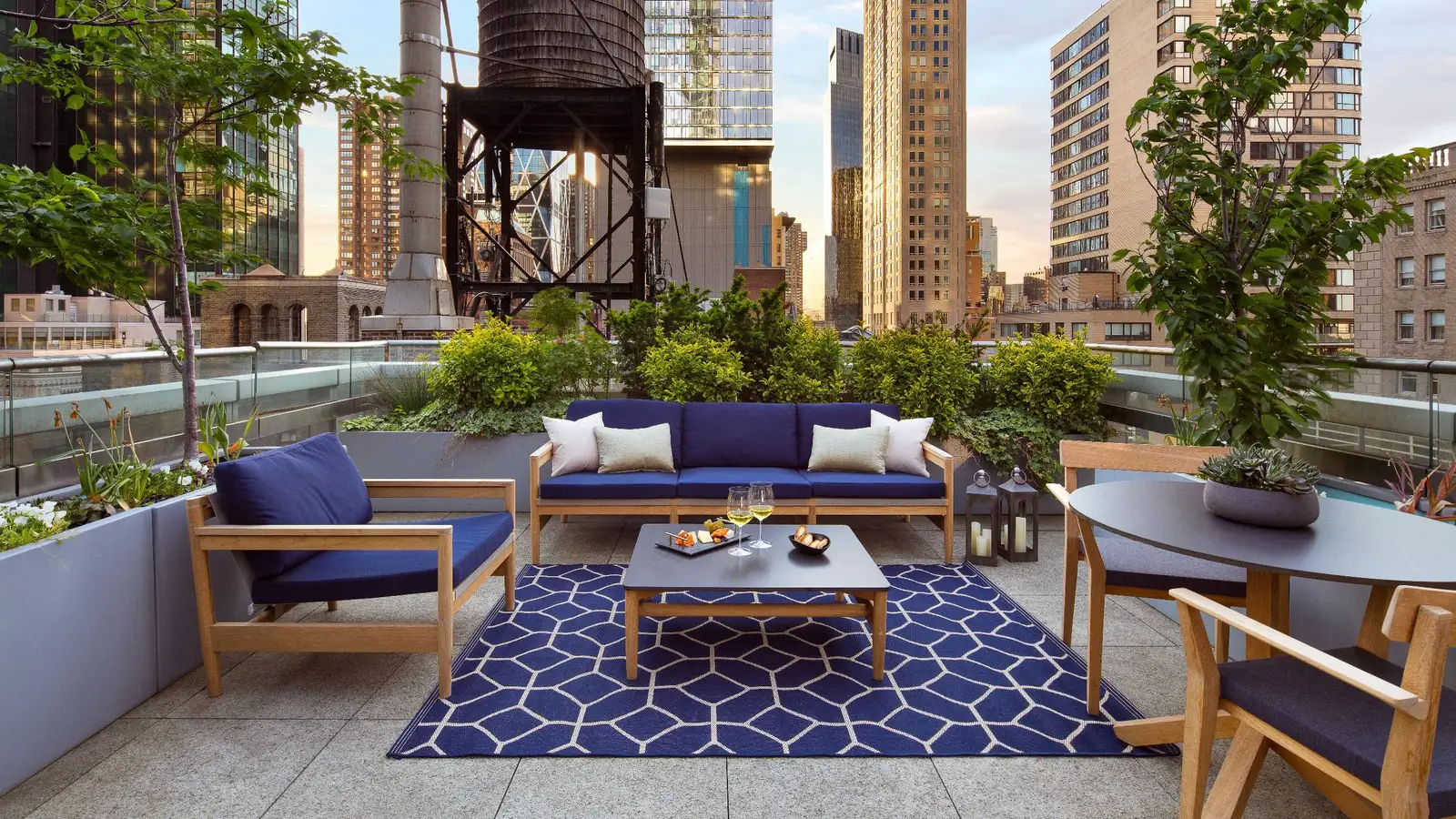 Terrace with blue sofas, planting and views of Manhattan buildings