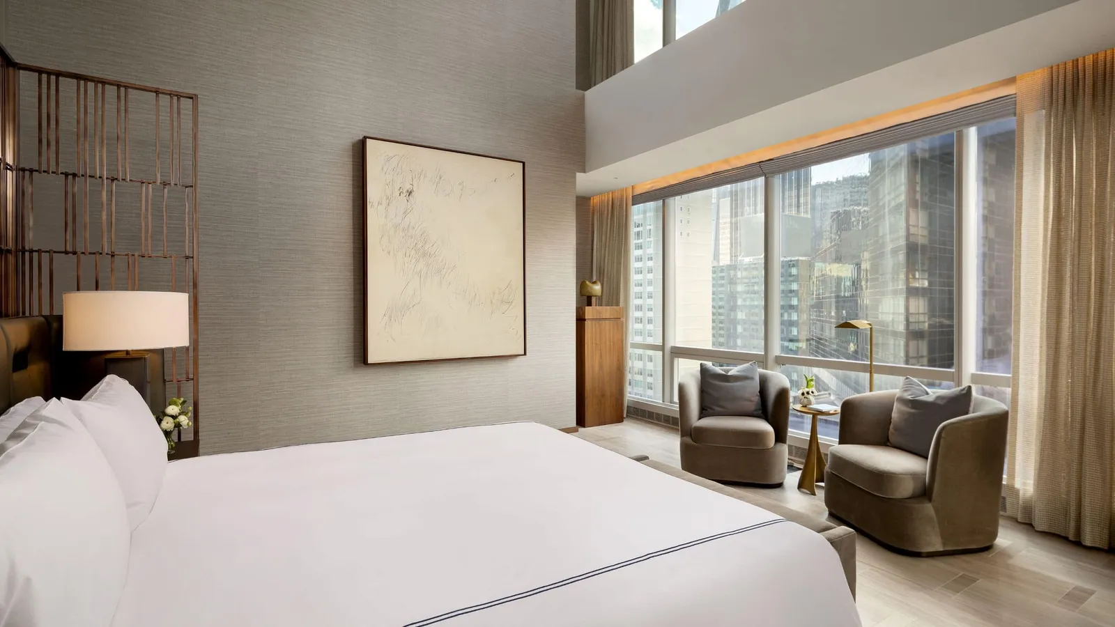 Manhattan Suite bedroom with tall windows and window-side armchairs