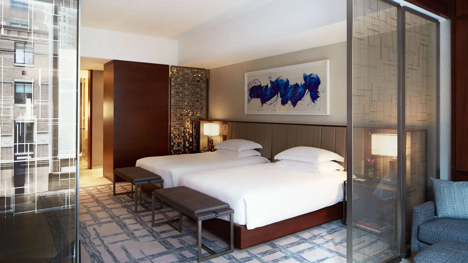 2 beds and a sitting area divided by decorative panels