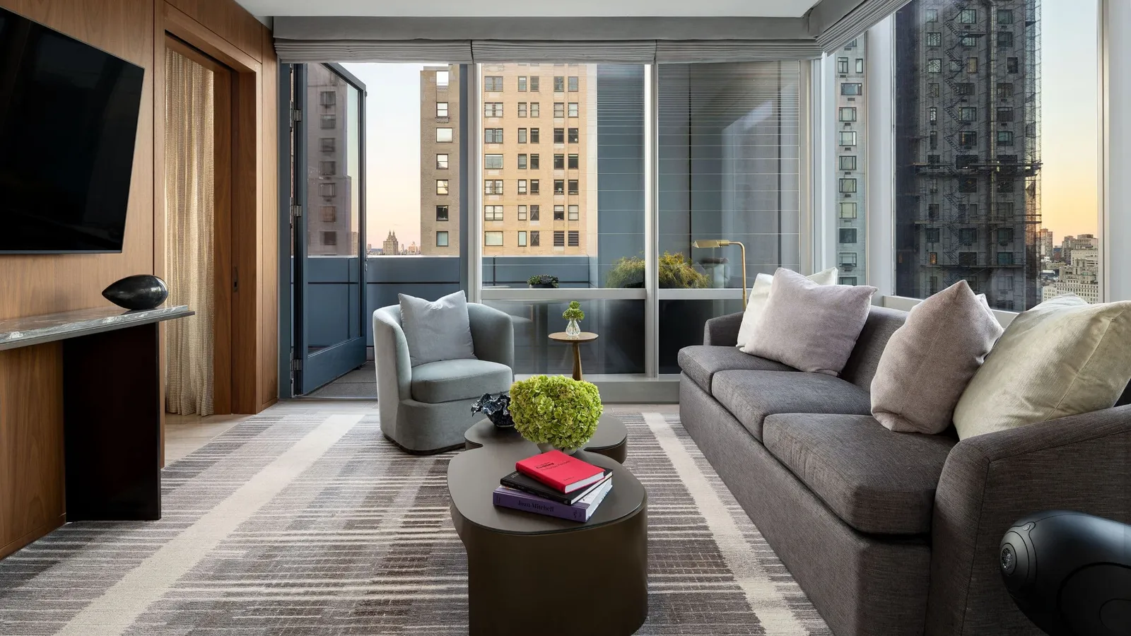 Sofa and armchair in a living room with an open balcony door