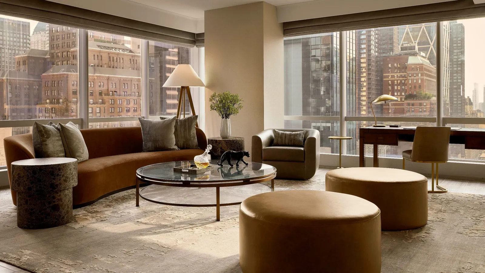 Living room with a tan sofa and corner windows facing Carnegie Hall