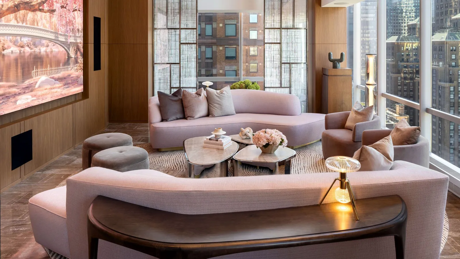 Manhattan Suite living room with curved sofas and a large wall-mounted screen