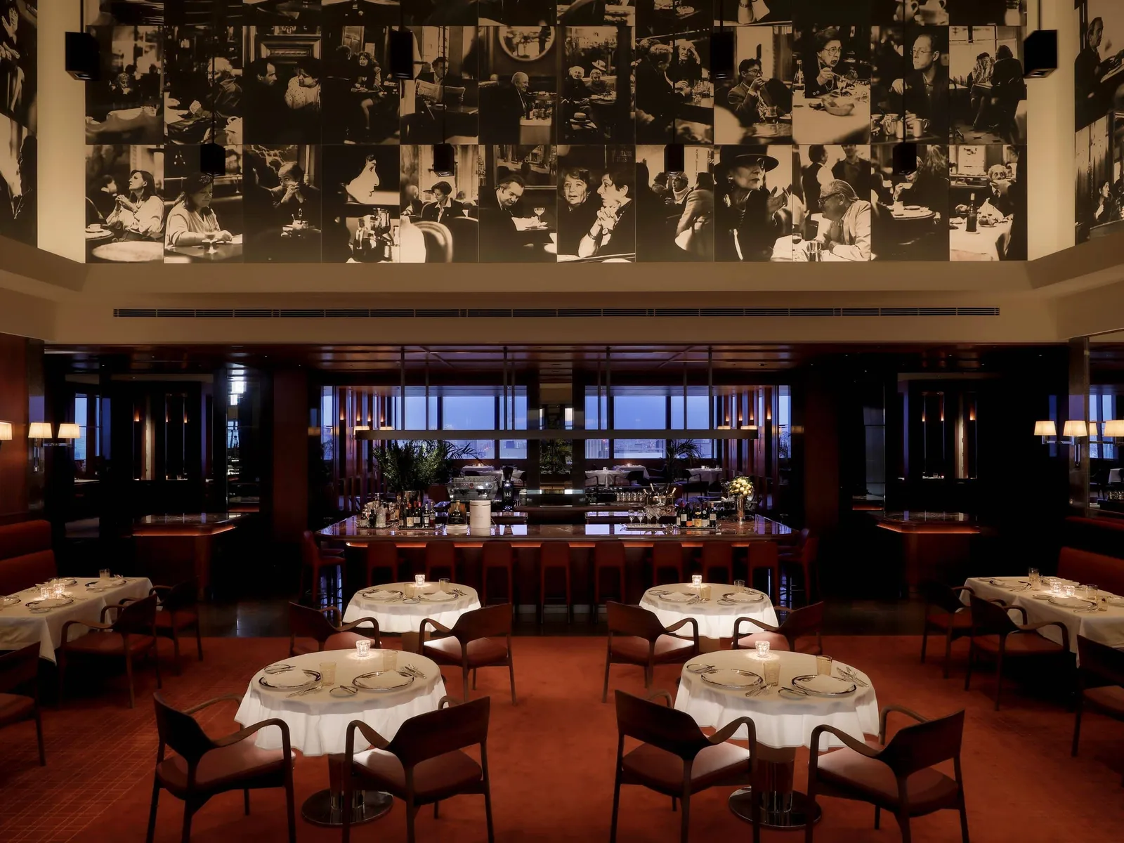 Girandole in the evening, under Vera Mercer’s collage of black and white photographs, with its round tables laid.