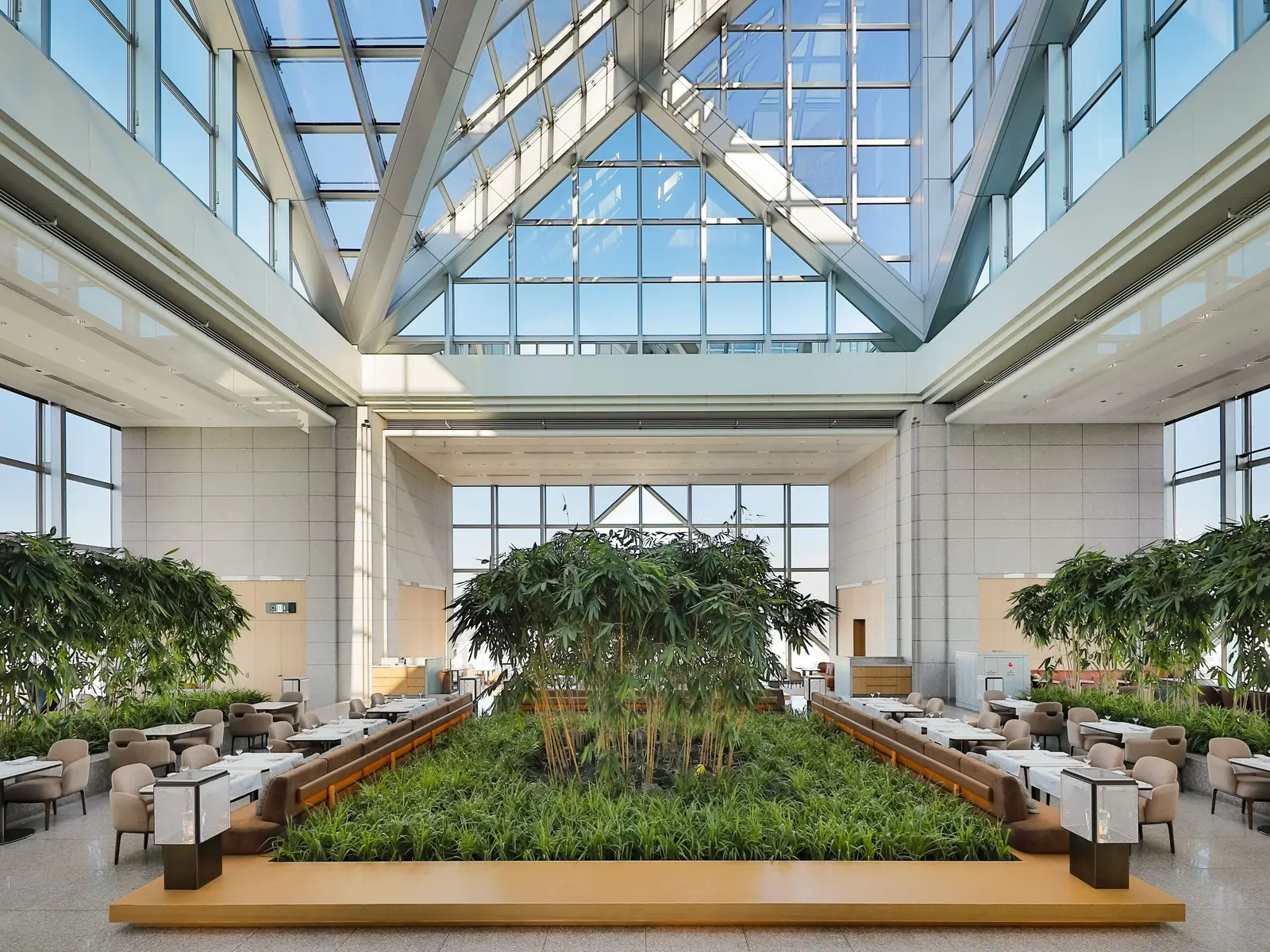 The Peak Lounge on the 41st floor: the glass pyramid atrium, the bamboo grove in the middle and the tables around it.