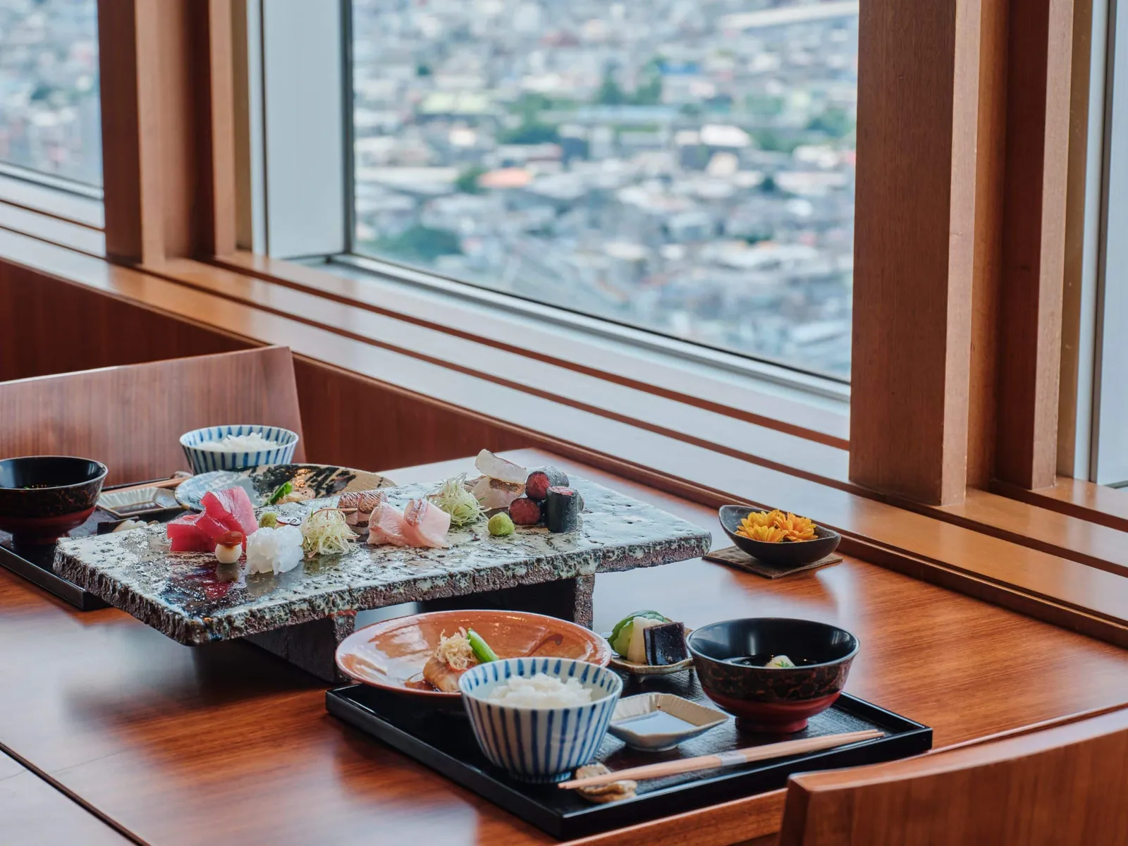 Lunch at Kozue by the window: sashimi on a glass plate, rice, soup and ceramic bowls.