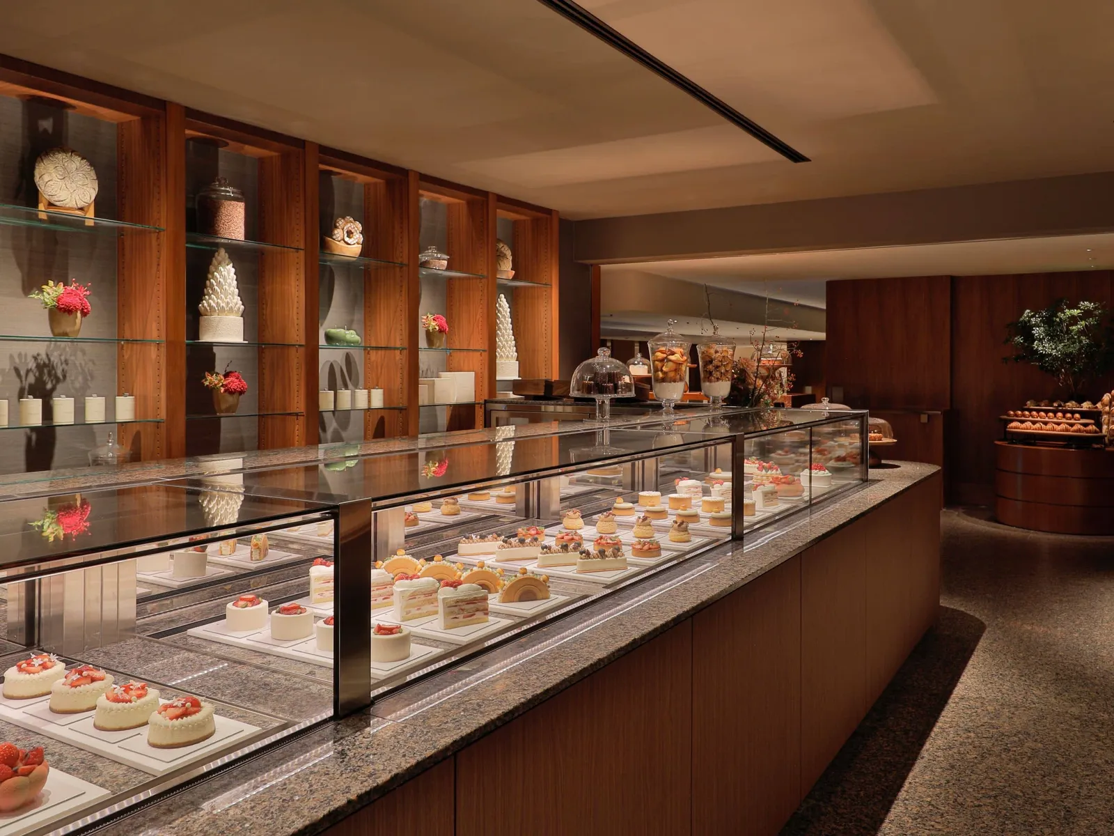 The Pastry Boutique: the cake counter and the cakes displayed on wooden shelves.
