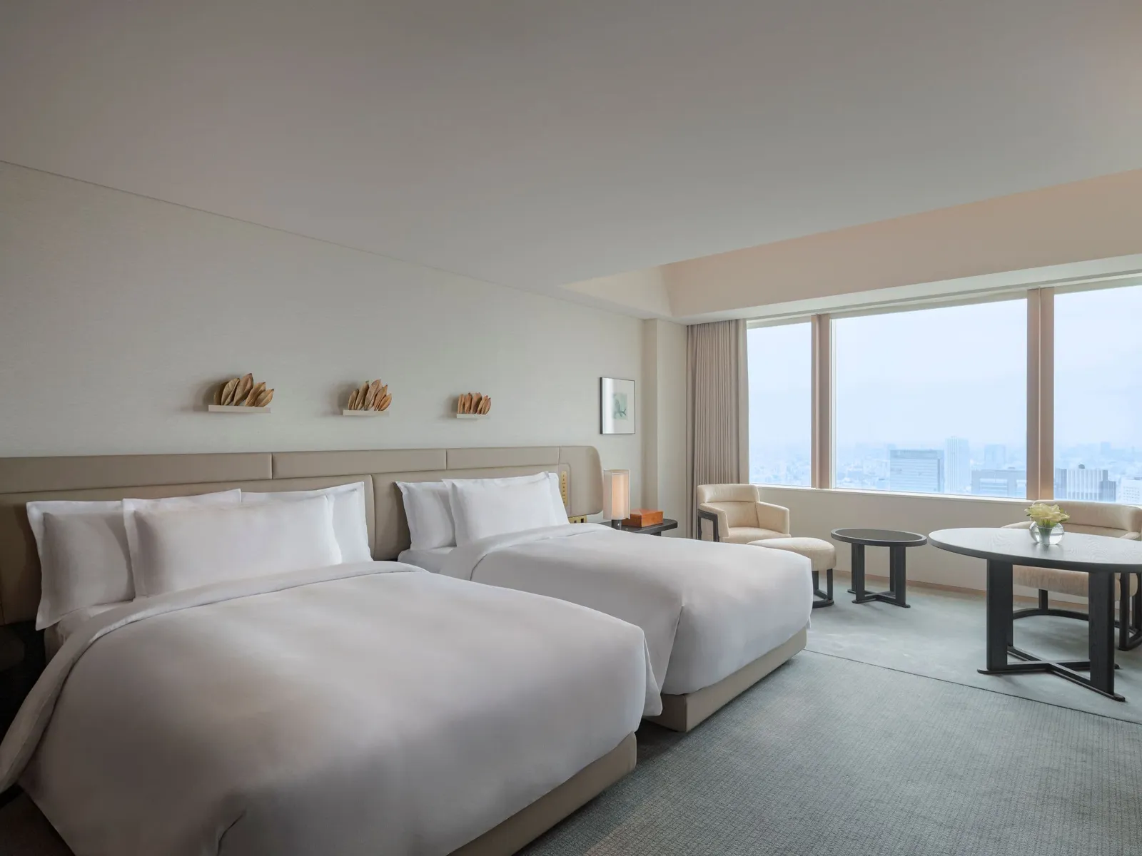The Deluxe with 2 double beds, the small table and the large windows onto the city.