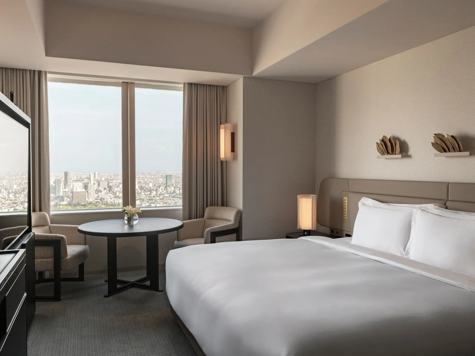 The King City View: the bed, a table lamp and the window onto the city.