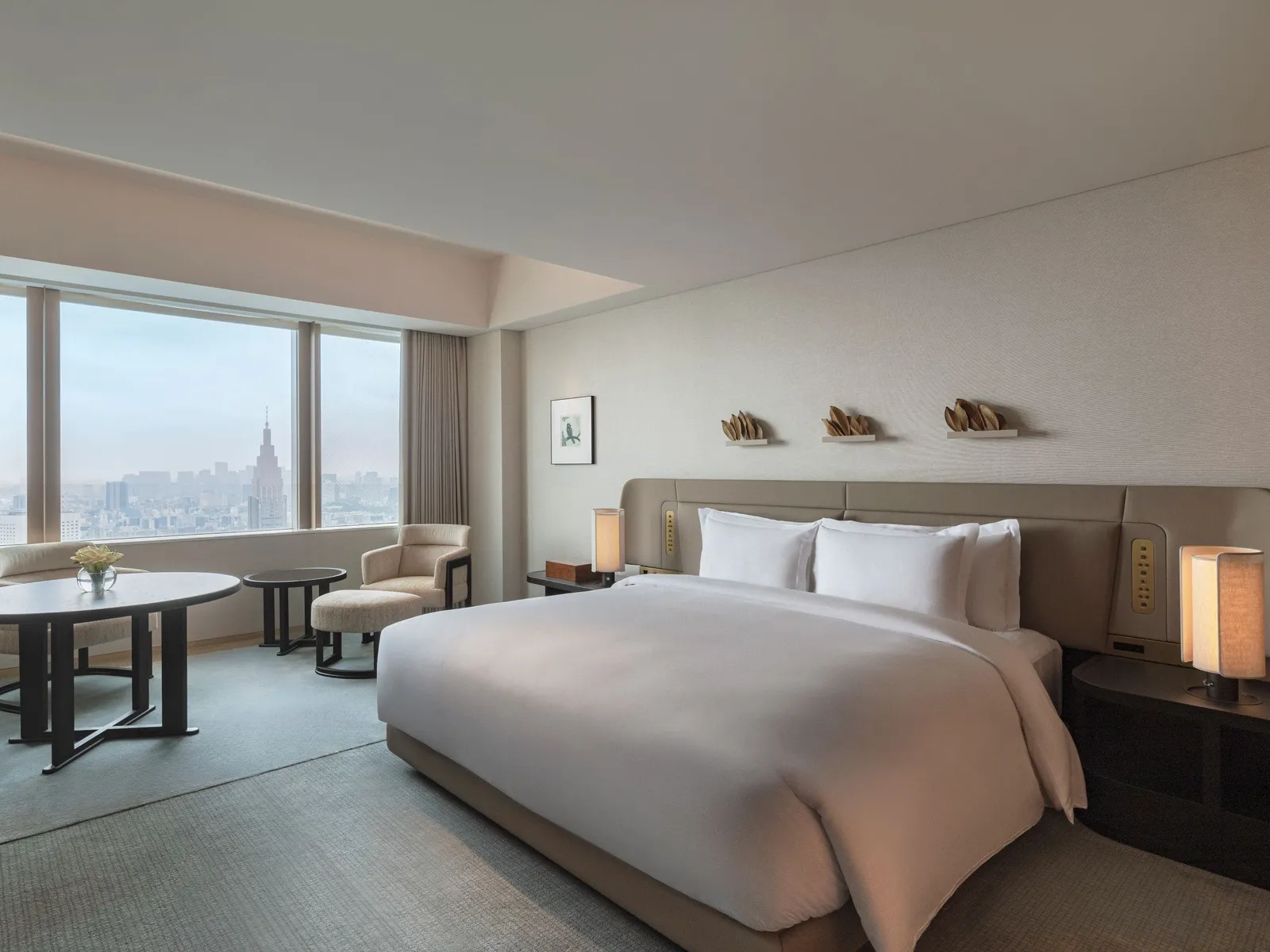 The King Deluxe: the bed, the round table and 2 windows onto the towers, one of them with a clock.