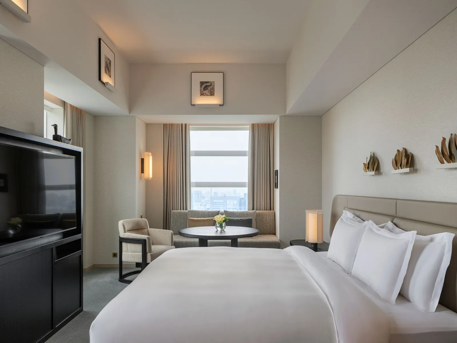 The King Premier: the bed with its cushions, the television, the small table and the corner window.