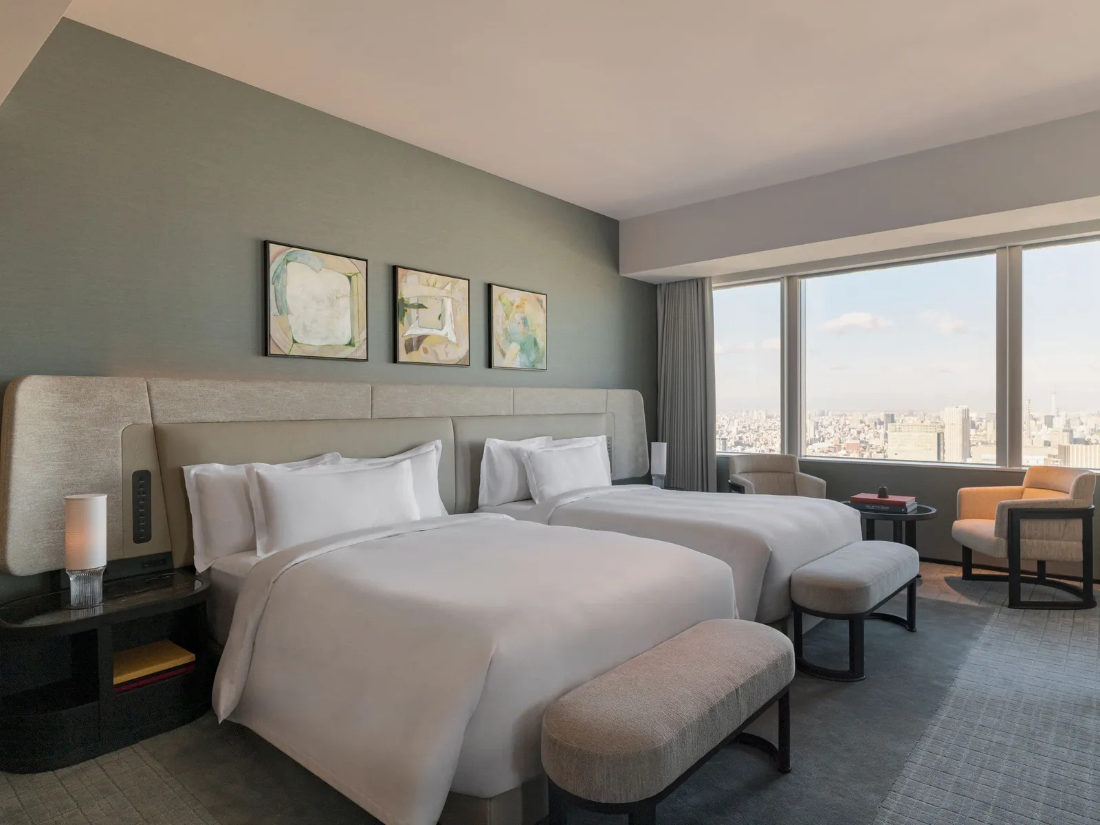 The Diplomat Suite bedroom with 2 double beds, the sage green wall and the window onto the city.
