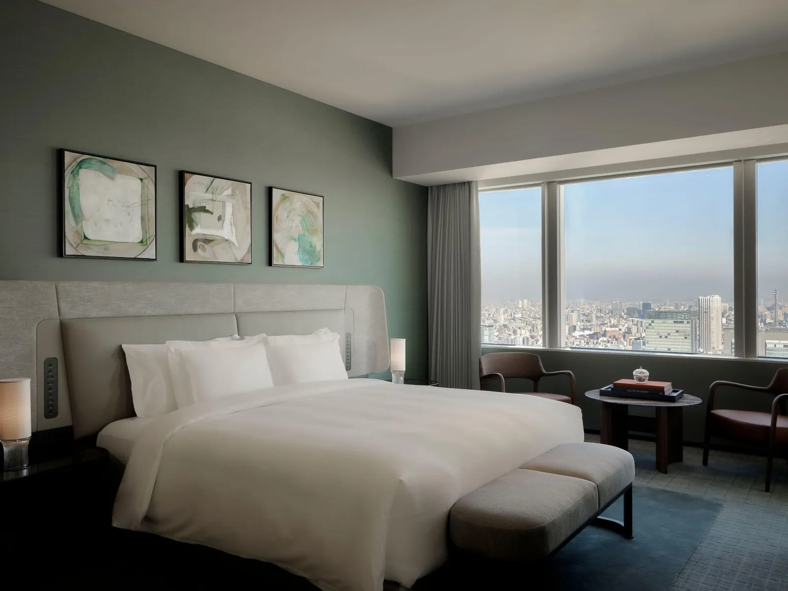 The Diplomat Suite bedroom with the king bed, 3 pictures above the headboard and the corner window.