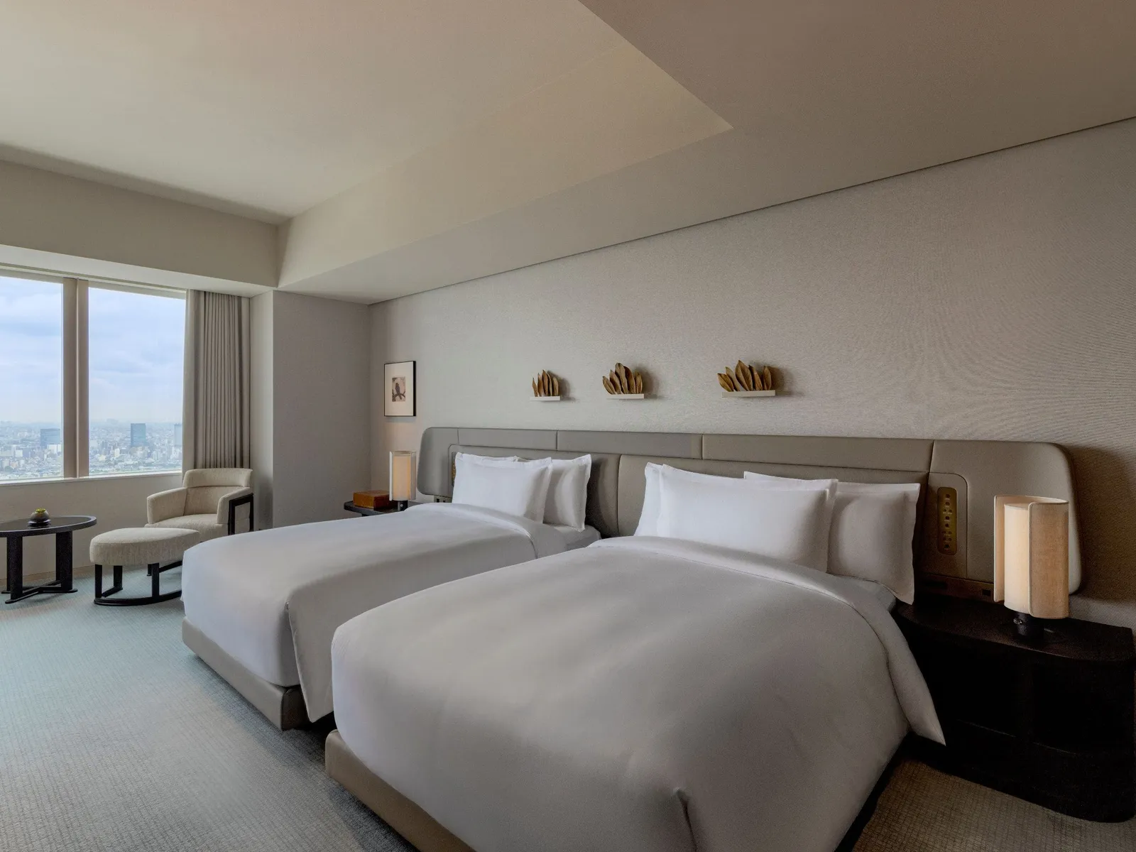The bedroom of the Park Suite with 2 double beds and the window onto the city.
