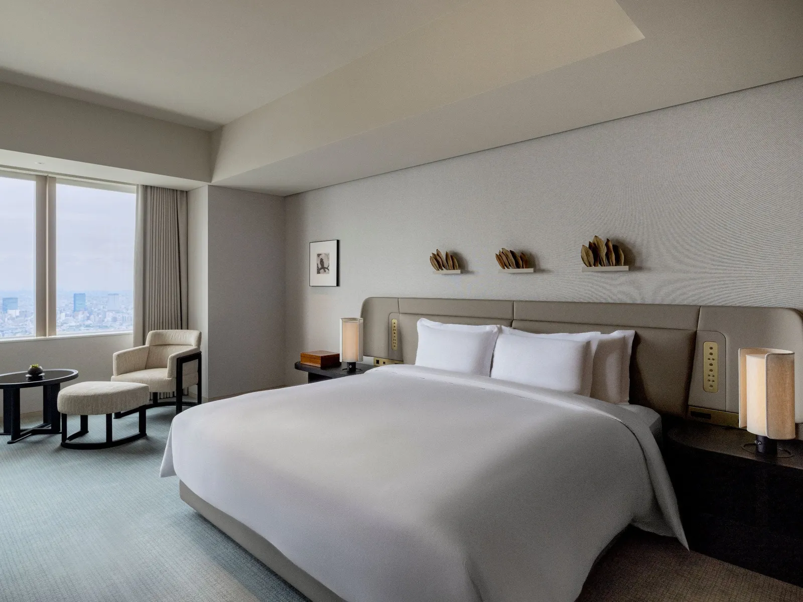 The bedroom of the Park Suite with the king bed, an armchair and the window onto the city.