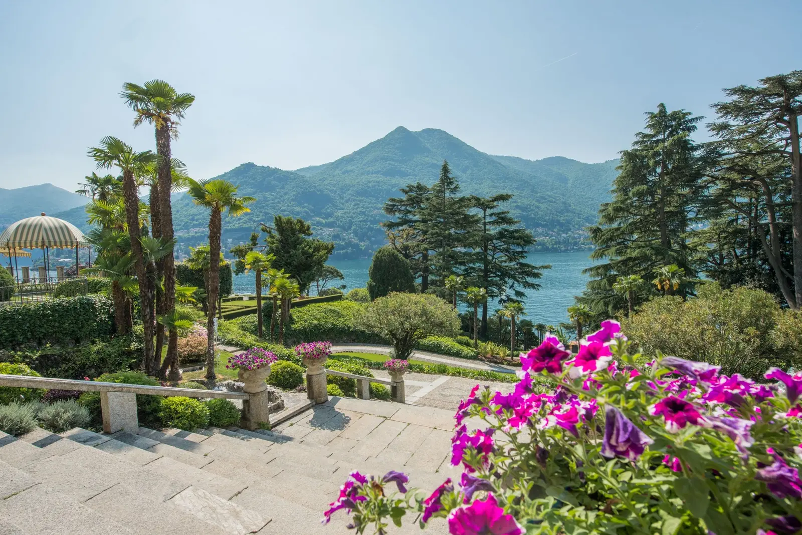 The terraced gardens with palms and flowers above the lake