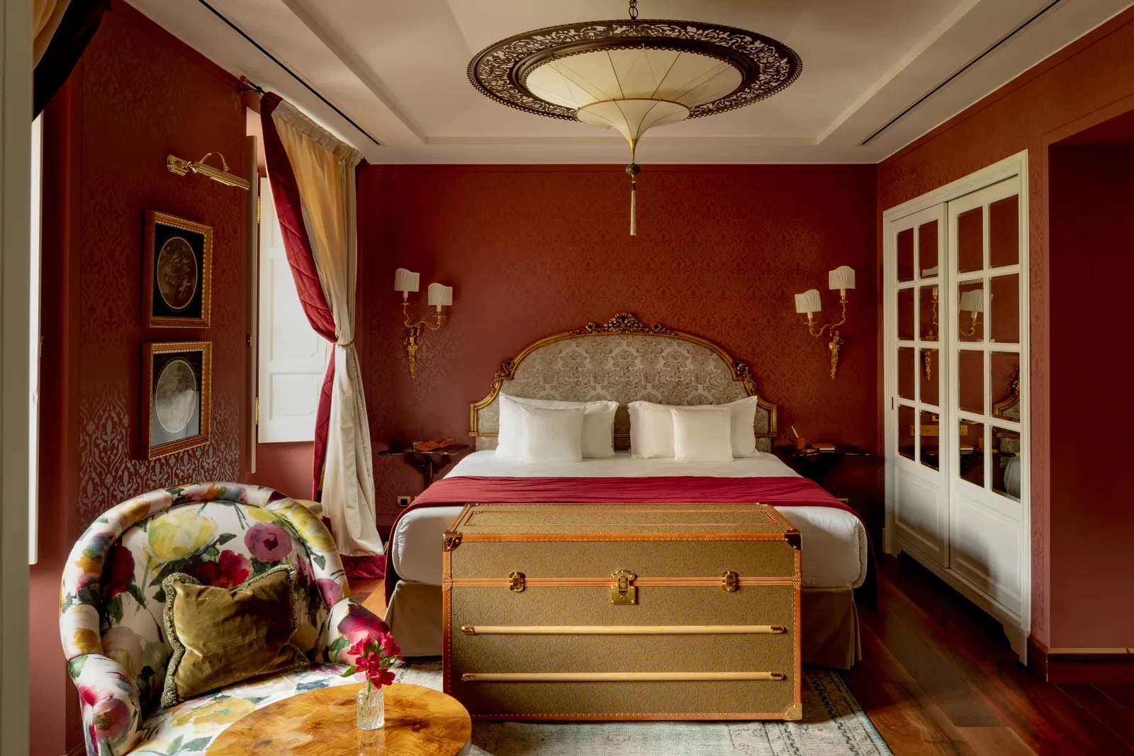Room in the Palazz with a red wall and the bed