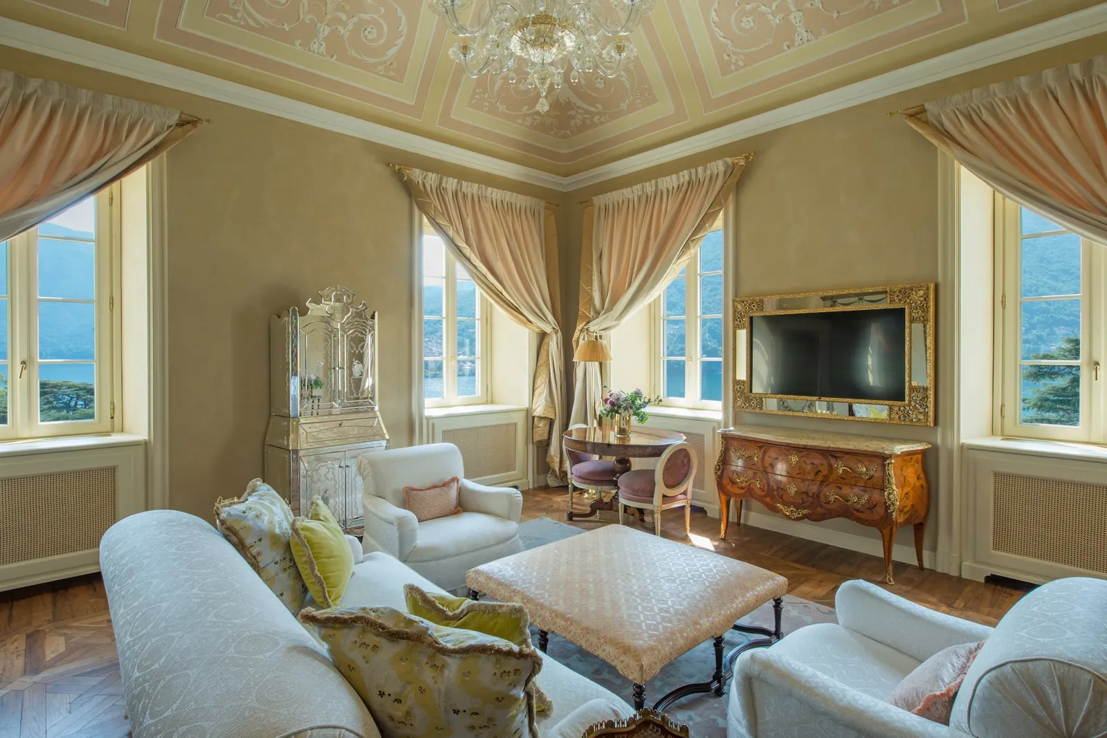 Suite Norma’s salon with white sofas and the lake at the windows