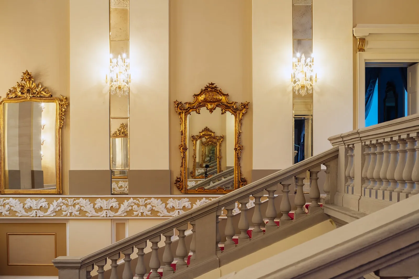 The main staircase with gilt mirrors and wall lights