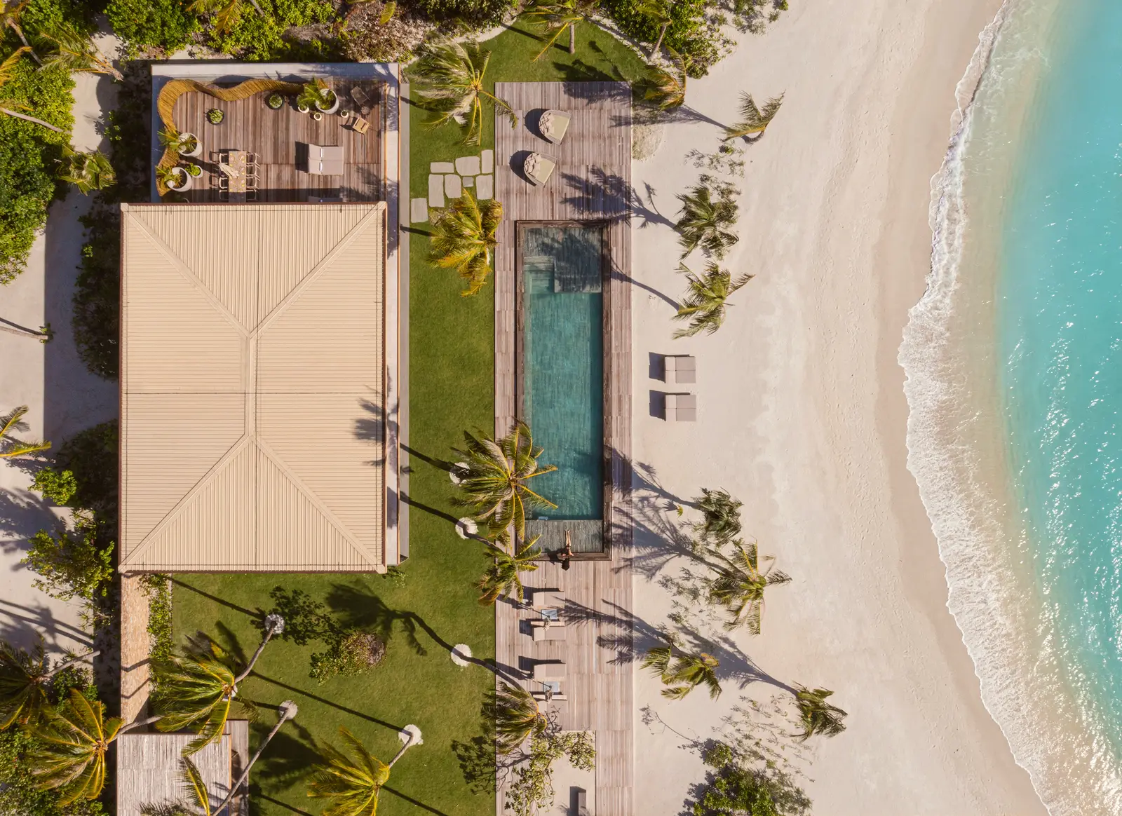 A beach villa from above: the roof, the garden, the pool and the sand on the lagoon