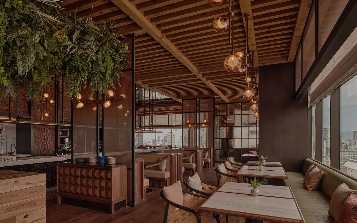 IÑAKI: tables under globe lights and hanging greenery, the city through tall windows