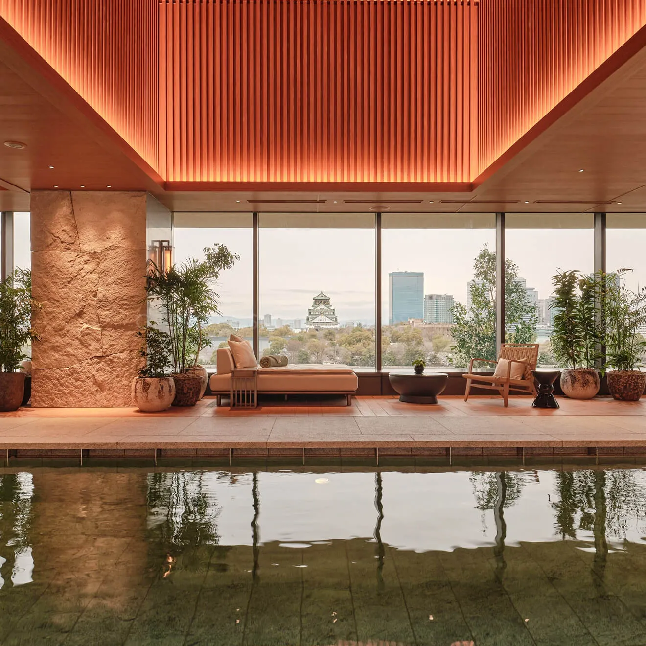 The indoor pool at dusk, Osaka Castle lit up through the windows at the far end