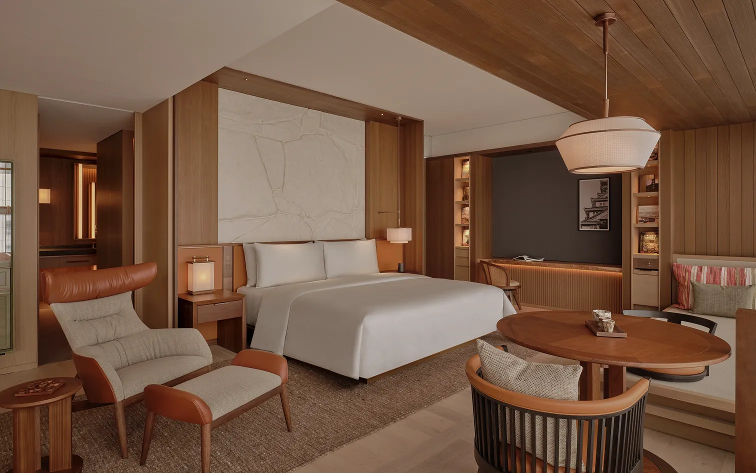 A Deluxe Suite: a king bed, a leather lounge chair and a round table