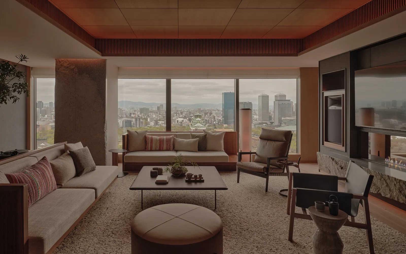 The Patina Suite’s living room: long sofas, a low table and windows over the city