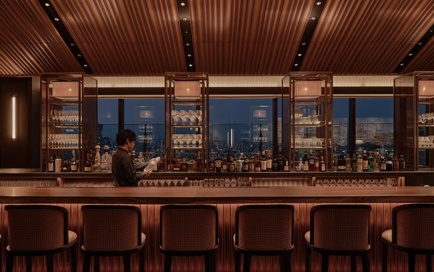 Sonata Bar & Lounge: a long counter with stools, the city at night through the glass