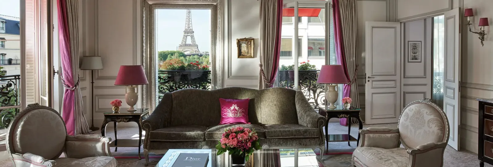 A sitting room with a sofa, coffee table and the Eiffel Tower through the window