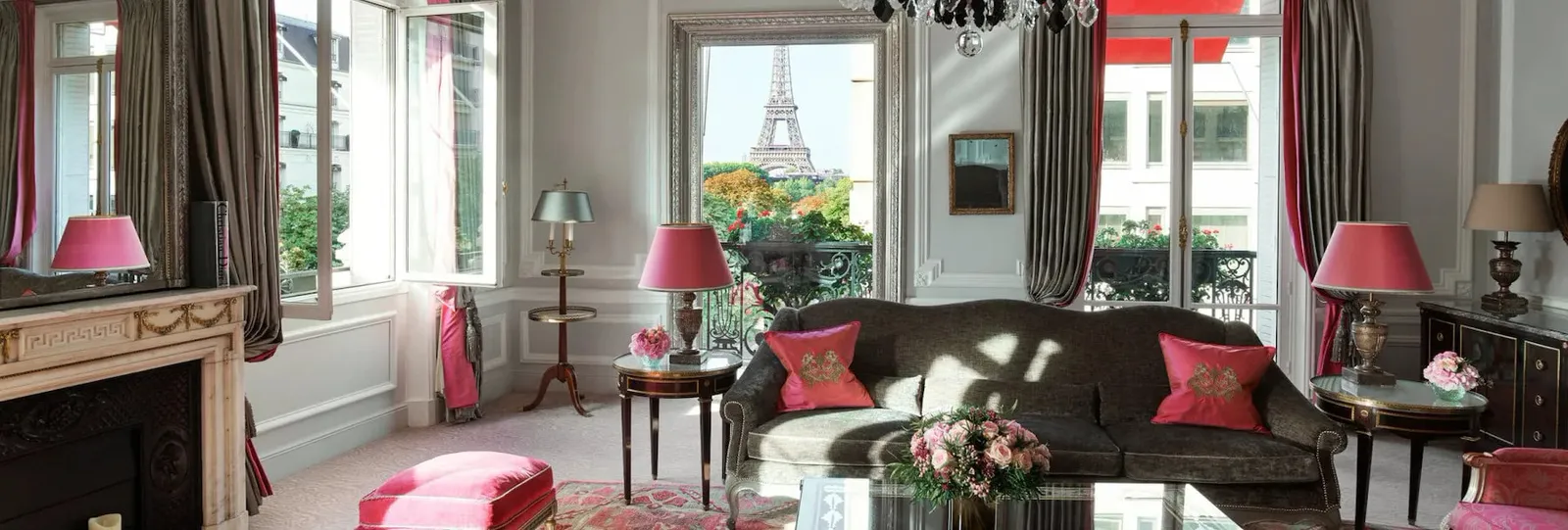A living room with a sofa, fireplace and the Eiffel Tower visible through the window
