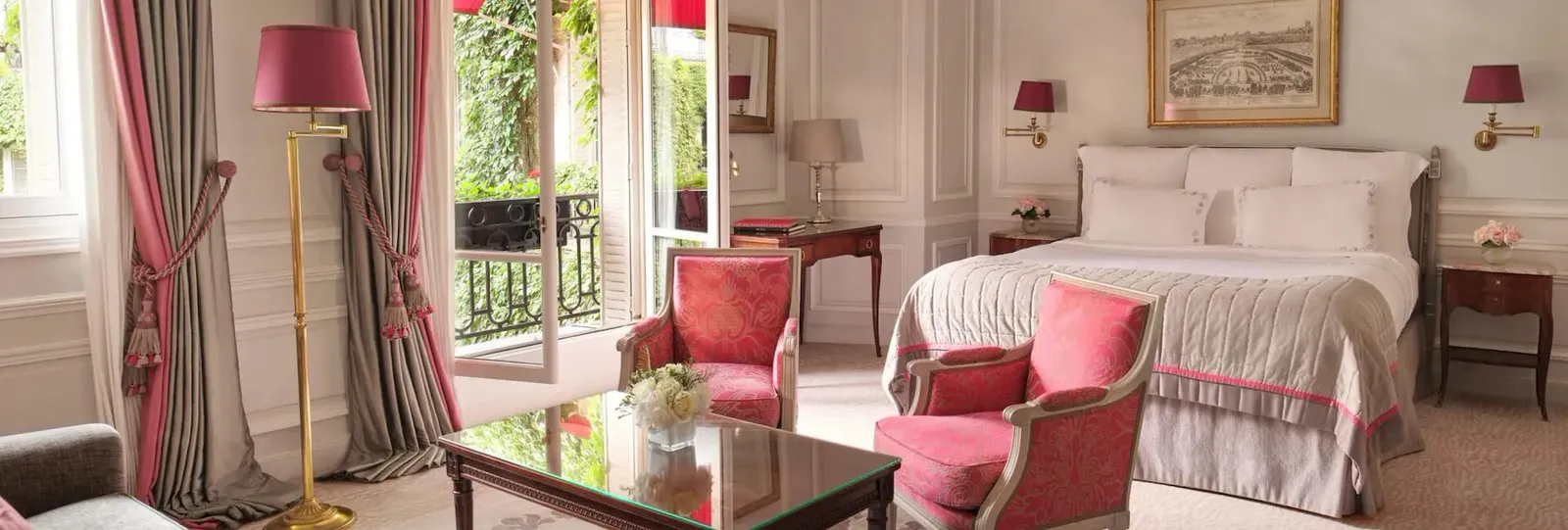 Junior Suite with a bed, red seating and open French doors