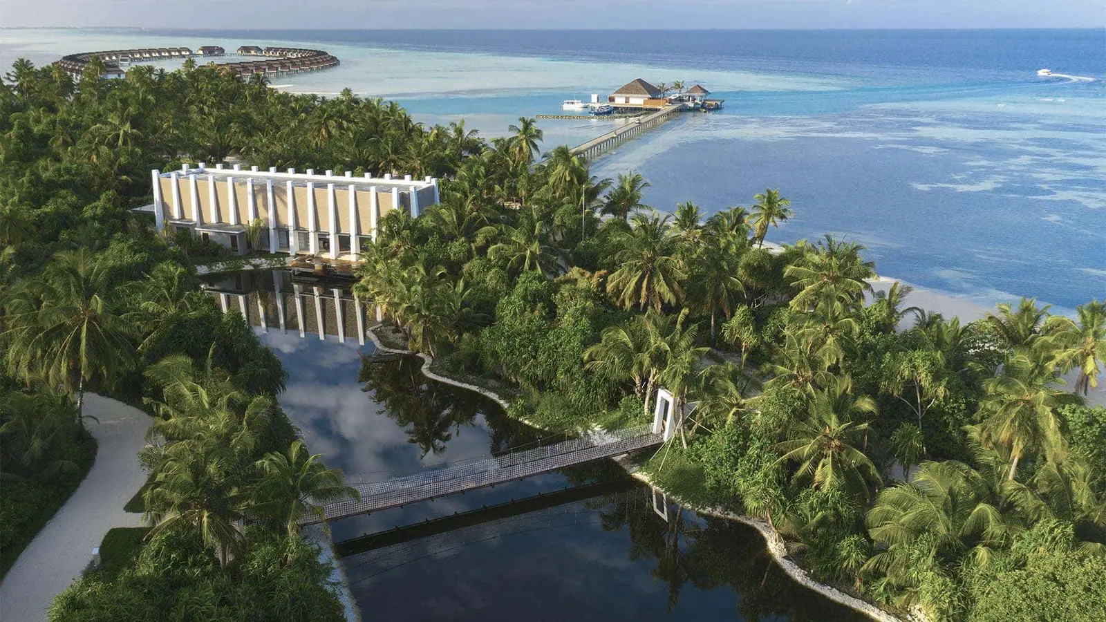 The island from above, the natural lake in the greenery, the bridge and the jetty out to sea.