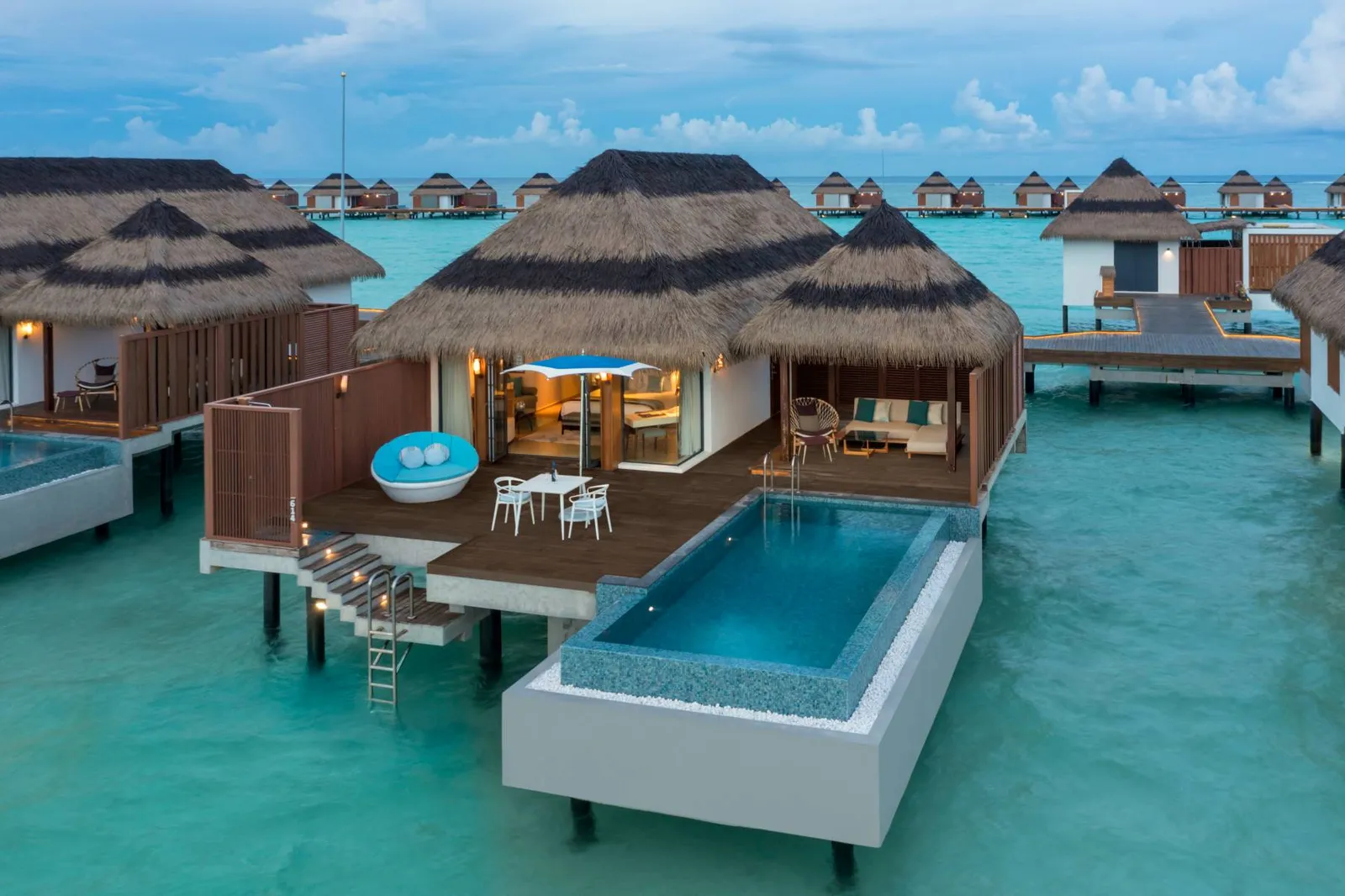 A Sunset Ocean Pool Villa, with its pool, deck chairs and ladder into the lagoon.