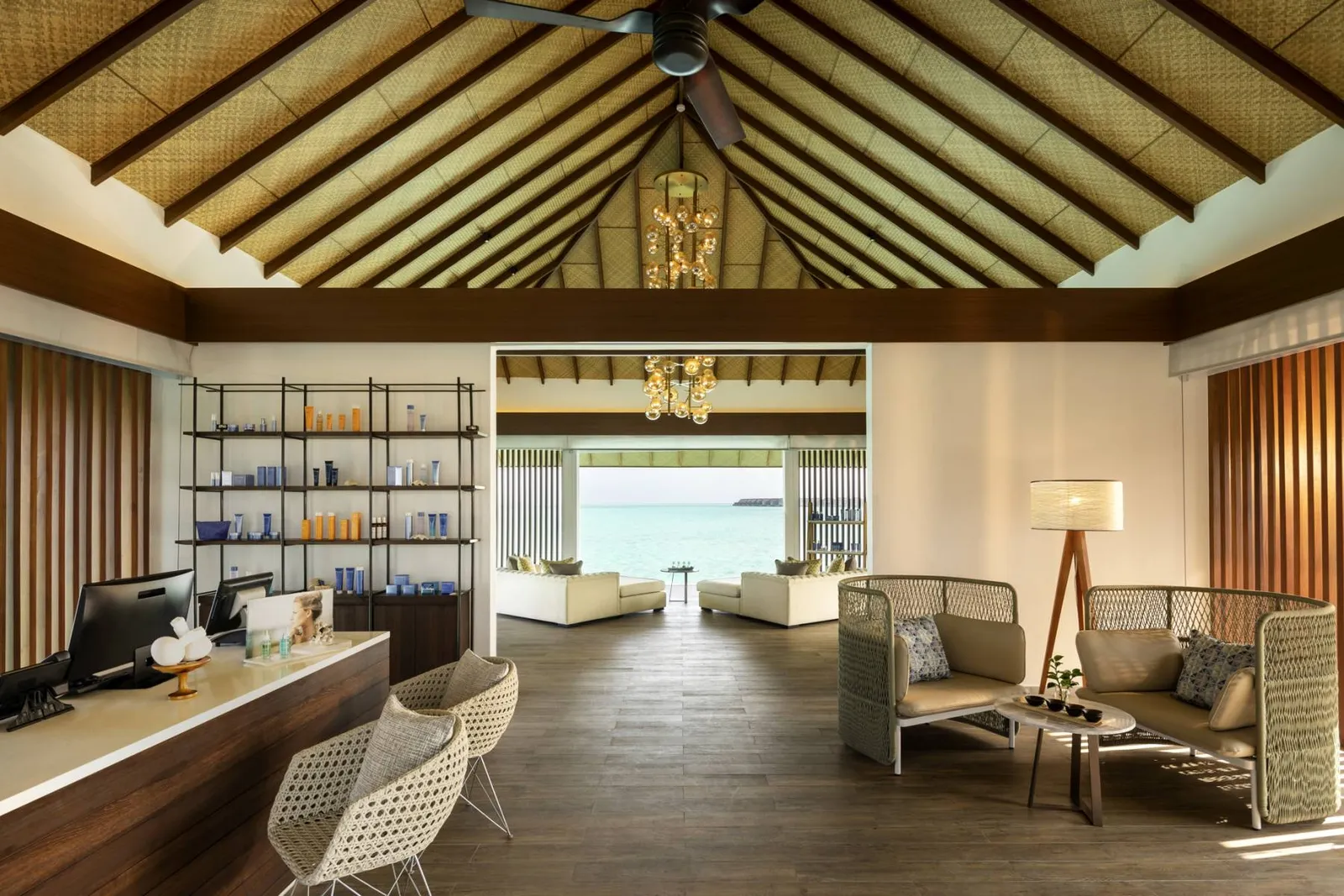 The overwater spa’s reception: the desk, the armchairs and the lagoon at the end of the room.