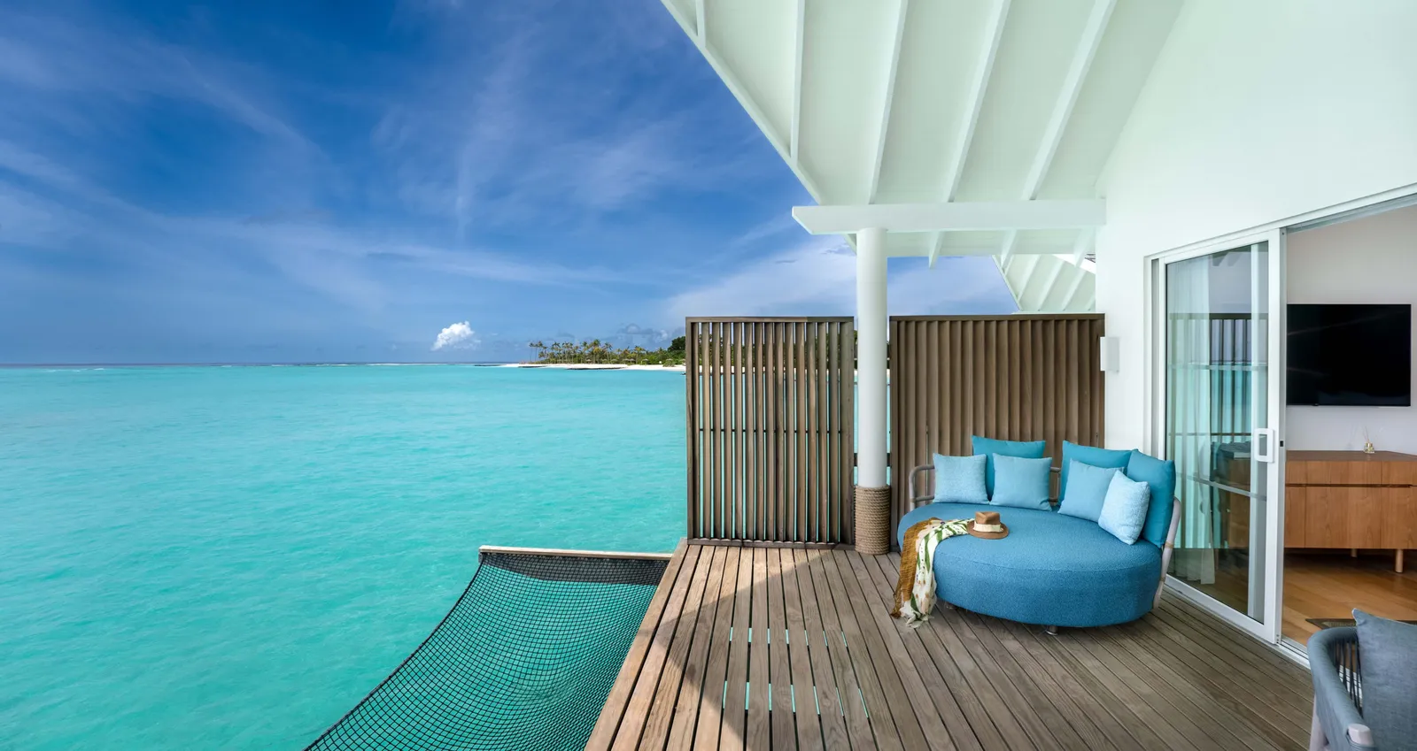 A Water Villa’s deck over the lagoon, with the round blue lounger and the net slung over the water.