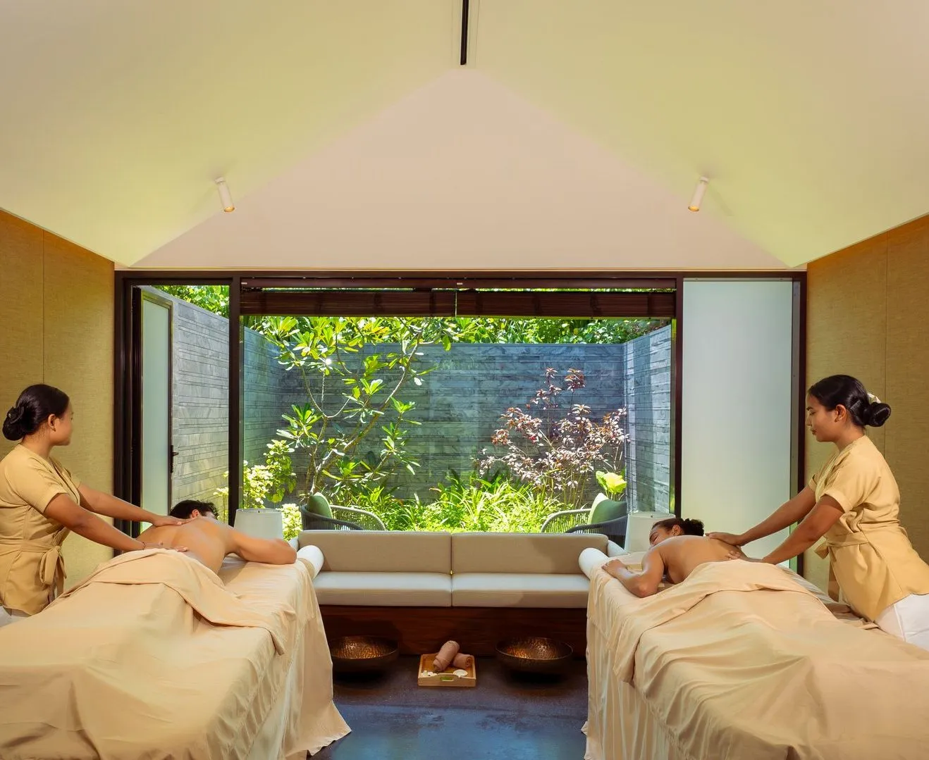 An ELE|NA Ayur room for couples: 2 beds, 2 therapists and a wide window onto the garden.
