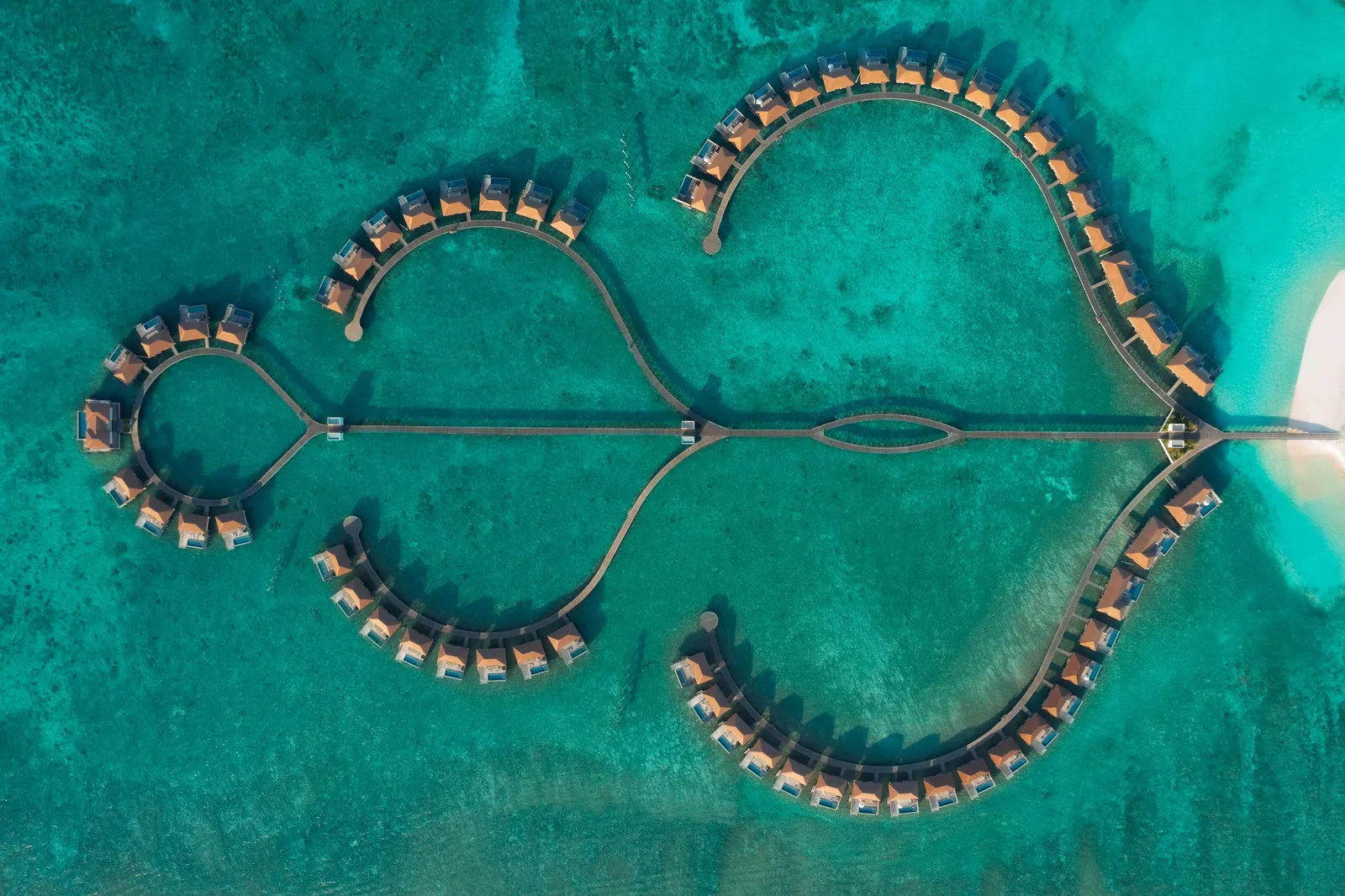 Seen from above, the overwater villa jetties trace 2 great loops on the lagoon.